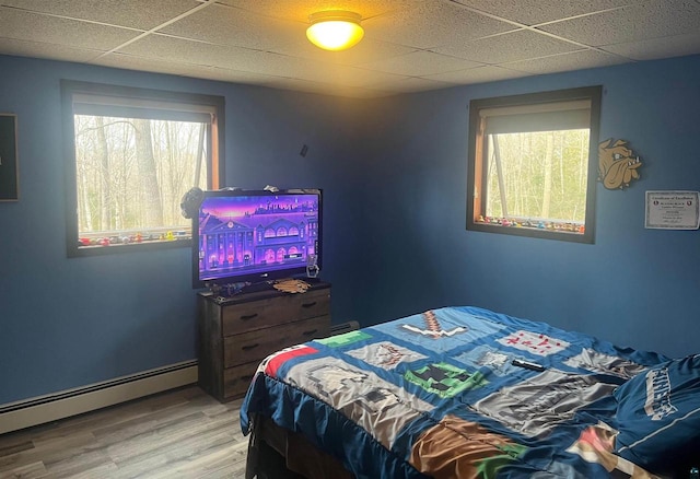 27200 N Maple Hill Rd, Washburn, WI 54891 - bedroom with baseboard heating, wood finished floors, and a drop ceiling