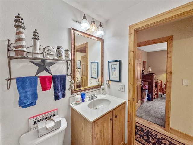 10244 124th St, Chippewa Falls, WI 54729 - half bathroom featuring vanity, toilet, and wood finished floors