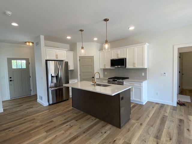 1107 Kampereschroer Way, Sun Prairie, WI 53590 - kitchen featuring stainless steel appliances, wood finished floors, light countertops, white cabinetry, and backsplash