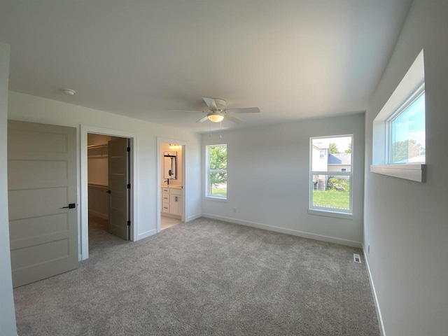 1107 Kampereschroer Way, Sun Prairie, WI 53590 - unfurnished bedroom featuring a spacious closet, carpet flooring, a closet, ceiling fan, and connected bathroom