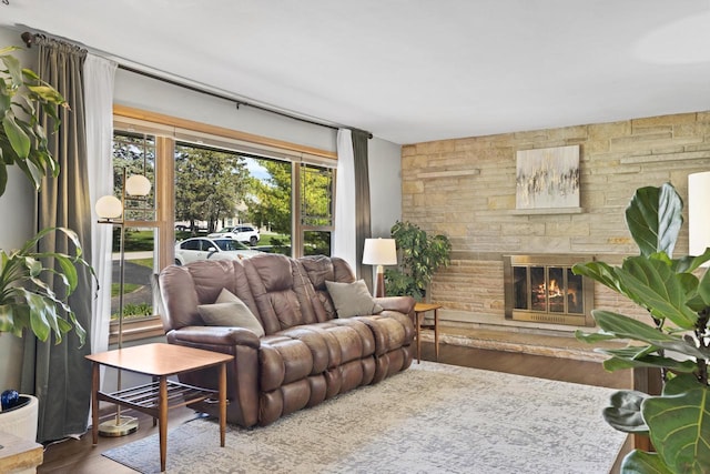living area featuring a stone fireplace and wood finished floors
