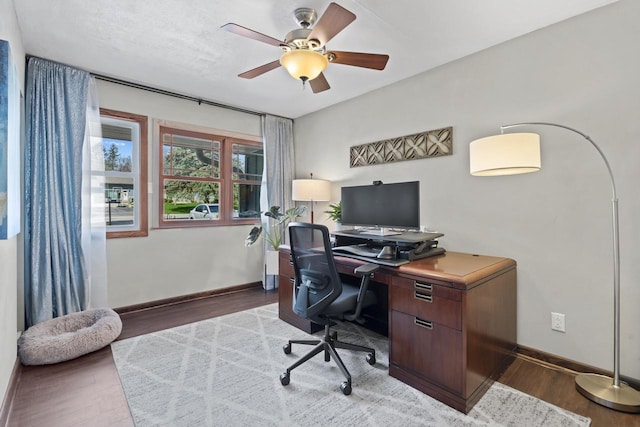 office featuring a ceiling fan, baseboards, and wood finished floors