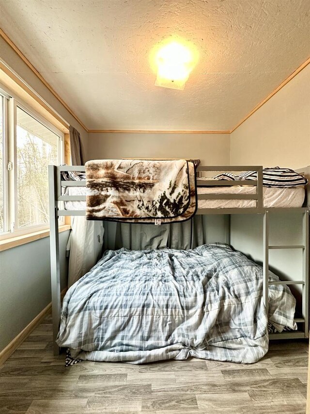 N7824 Typner Lake Rd, Deerbrook, WI 54424 - bedroom with baseboards, a textured ceiling, and wood finished floors