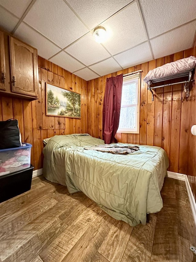 N7824 Typner Lake Rd, Deerbrook, WI 54424 - bedroom featuring wood walls, a paneled ceiling, baseboards, and wood finished floors