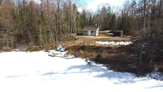 N7824 Typner Lake Rd, Deerbrook, WI 54424 - yard covered in snow with a wooded view, a storage unit, and an outdoor structure