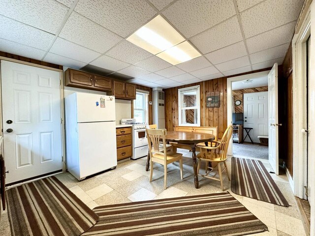 N7824 Typner Lake Rd, Deerbrook, WI 54424 - dining room with wooden walls, a drop ceiling, and light floors