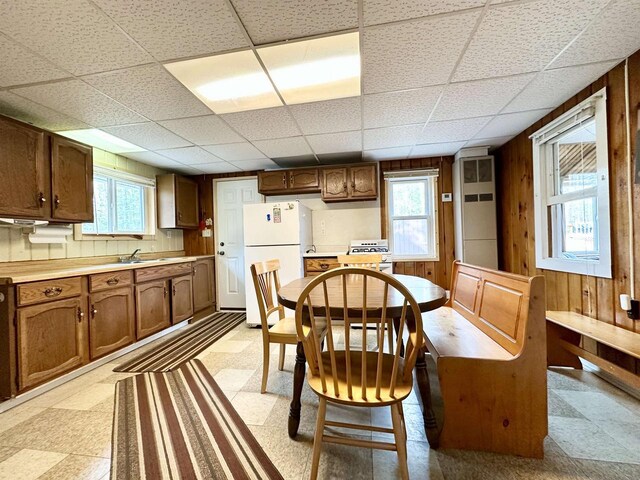 N7824 Typner Lake Rd, Deerbrook, WI 54424 - dining area with wood walls, a drop ceiling, light floors, and a healthy amount of sunlight