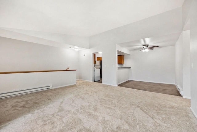 empty room featuring carpet, a ceiling fan, baseboard heating, a baseboard heating unit, and baseboards