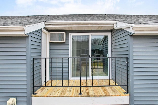 view of exterior entry featuring roof with shingles