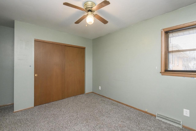 unfurnished bedroom with visible vents, baseboards, a closet, a ceiling fan, and carpet floors