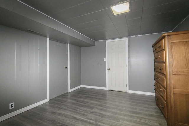 finished basement with visible vents, baseboards, and wood finished floors