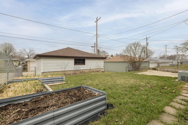 view of yard featuring an outdoor structure, a garden, fence, and central AC unit