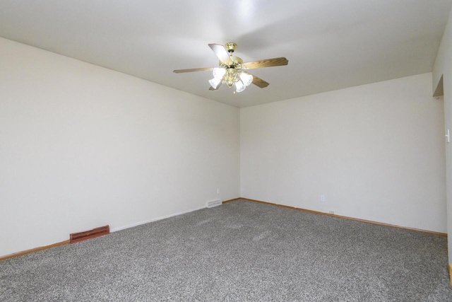 carpeted spare room featuring visible vents, baseboards, and ceiling fan
