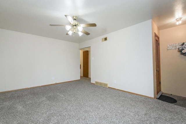 carpeted spare room with ceiling fan, baseboards, and visible vents