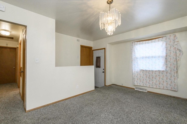 spare room featuring carpet flooring, visible vents, baseboards, and an inviting chandelier