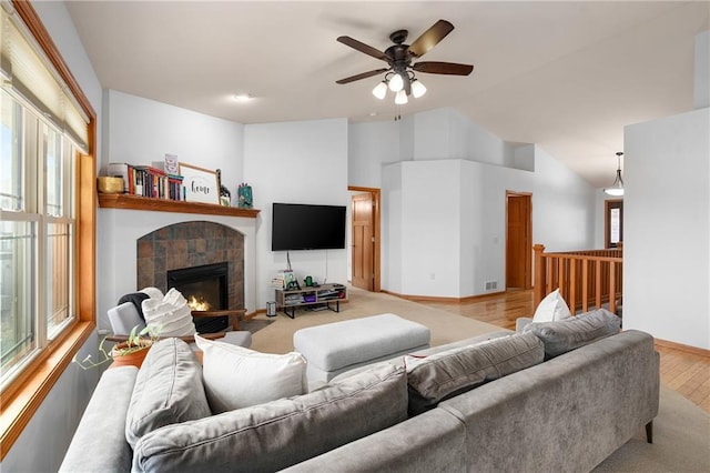 3943 Mill Run Rd, Eau Claire, WI 54703 - living area with wood finished floors, healthy amount of natural light, a ceiling fan, vaulted ceiling, and a tile fireplace