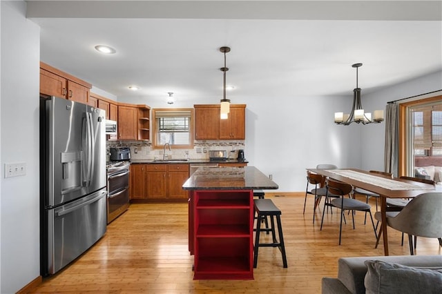 3943 Mill Run Rd, Eau Claire, WI 54703 - kitchen with open shelves, appliances with stainless steel finishes, a chandelier, decorative backsplash, and light wood-type flooring