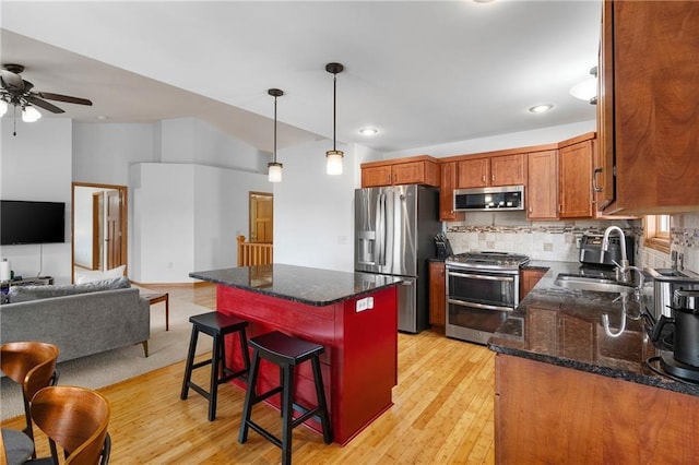 3943 Mill Run Rd, Eau Claire, WI 54703 - kitchen with stainless steel appliances, ceiling fan, open floor plan, light wood-type flooring, and a breakfast bar area