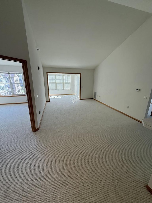 spare room featuring plenty of natural light, carpet flooring, and baseboards