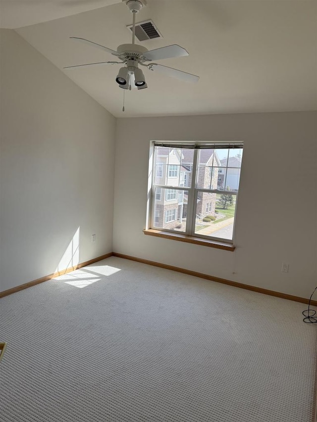 carpeted spare room with ceiling fan, baseboards, and visible vents