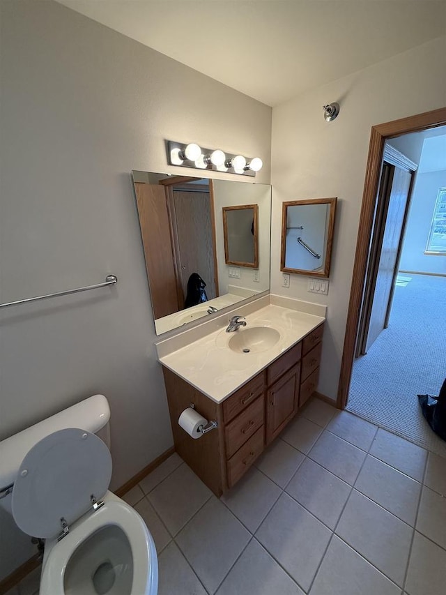 bathroom with toilet, tile patterned flooring, baseboards, and vanity