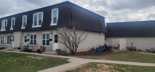 4141 W Cherrywood Ln, Brown Deer, WI 53209 - exterior space with brick siding, a front lawn, mansard roof, and roof with shingles