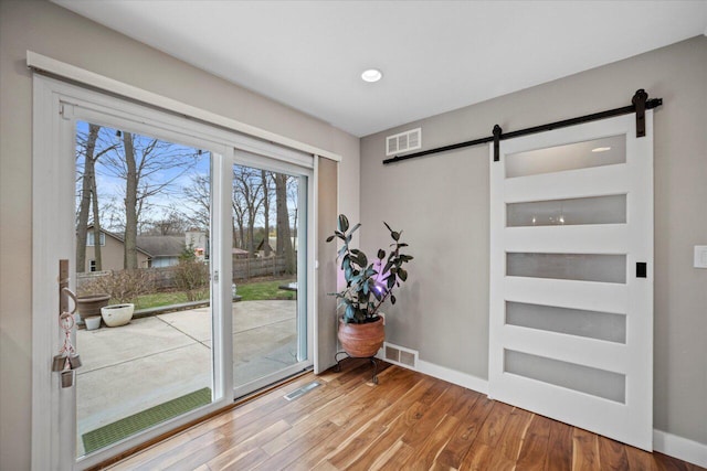 entryway featuring a barn door, visible vents, and baseboards