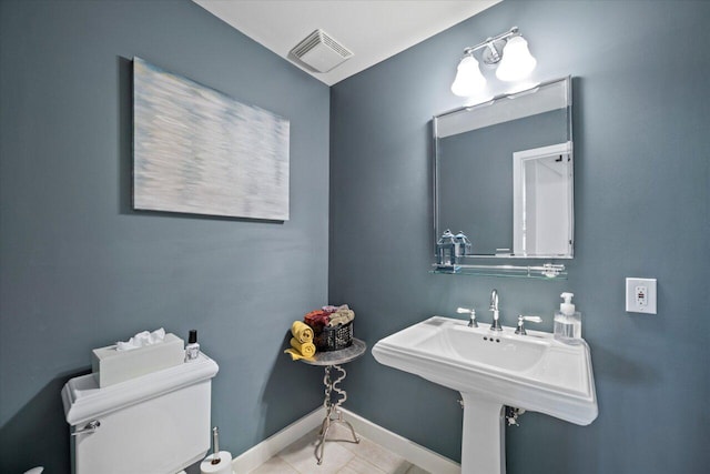 half bathroom with toilet, tile patterned floors, visible vents, and baseboards