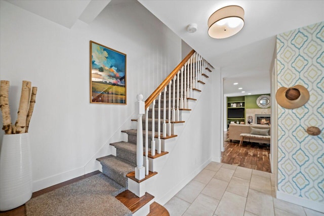 stairway featuring recessed lighting, baseboards, and a fireplace
