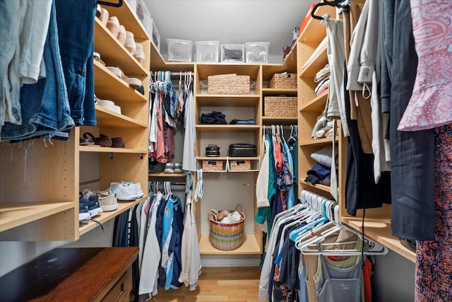 walk in closet with wood finished floors