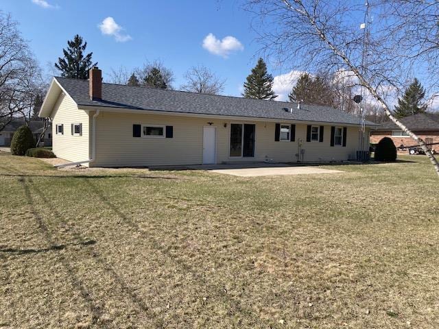 back of property featuring a patio area and a lawn