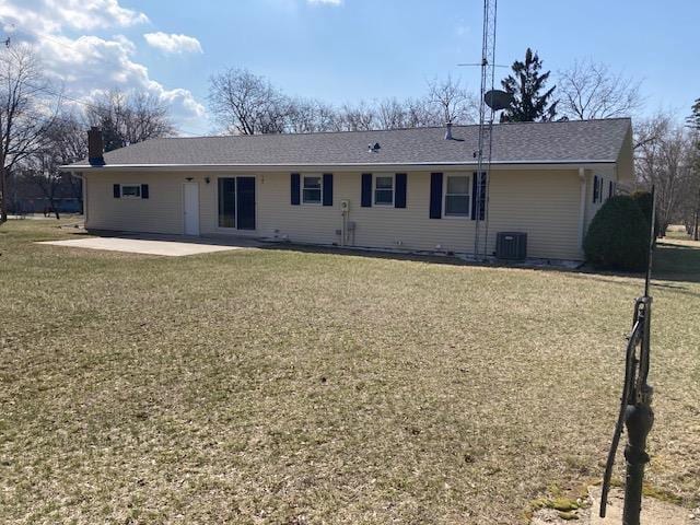 back of house featuring central air condition unit, a patio area, and a lawn
