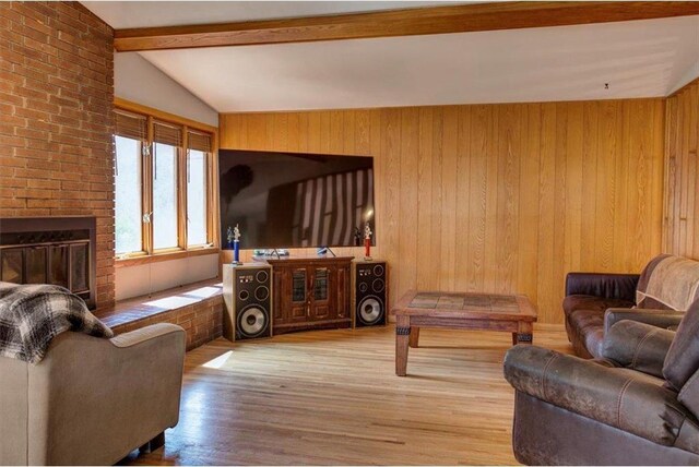 607 Cross Ave, Amery, WI 54001 - living area featuring wood finished floors, wood walls, lofted ceiling with beams, and a brick fireplace