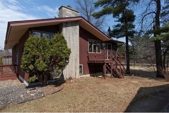 607 Cross Ave, Amery, WI 54001 - view of side of home with a chimney, a wooden deck, and stairway