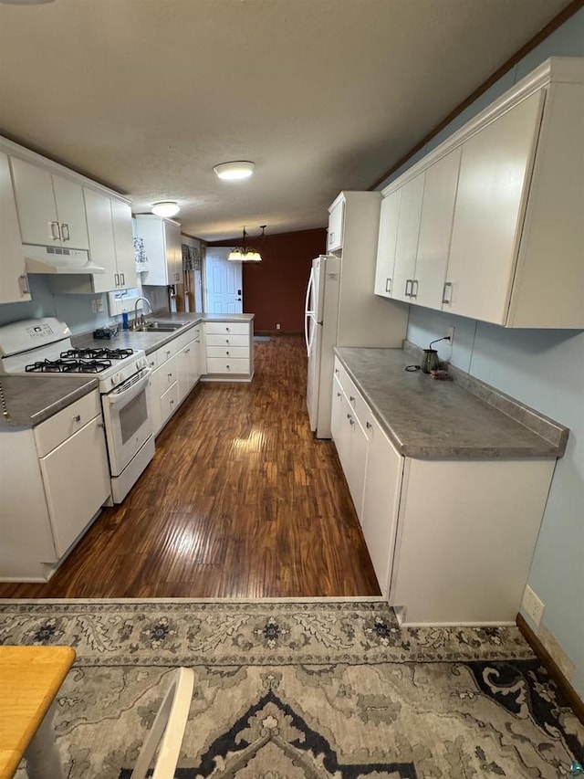 68485 N George St, Iron River, WI 54847 - kitchen featuring white appliances, a peninsula, under cabinet range hood, dark wood-style floors, and a sink