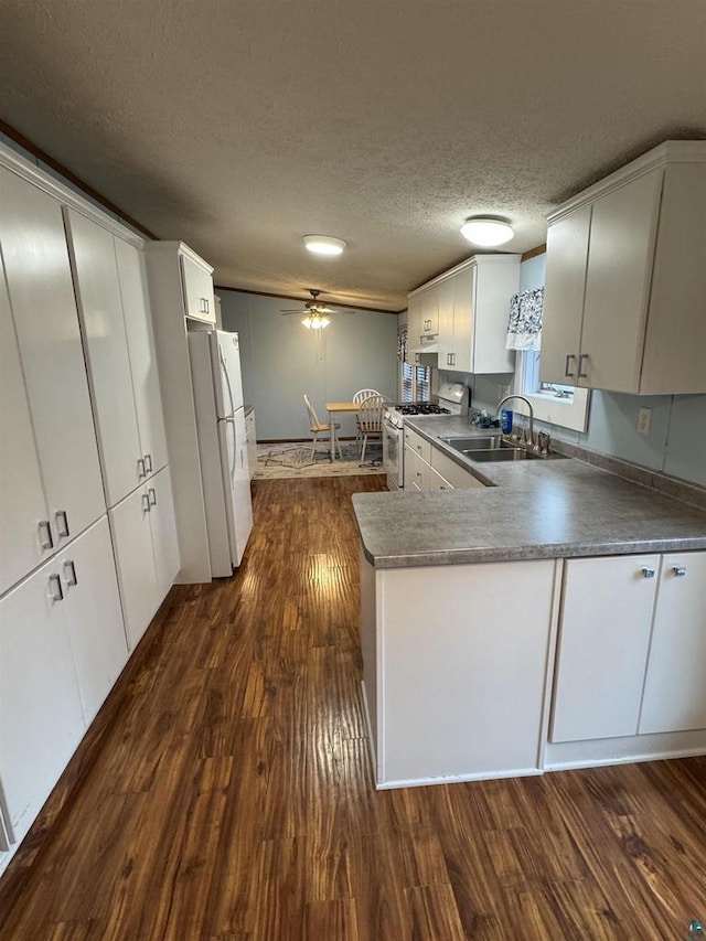 68485 N George St, Iron River, WI 54847 - kitchen featuring white appliances, a sink, dark wood-style floors, dark countertops, and white cabinetry