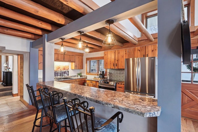 W9160 Ripley Rd, Cambridge, WI 53523 - kitchen featuring brown cabinetry, a peninsula, appliances with stainless steel finishes, and plenty of natural light