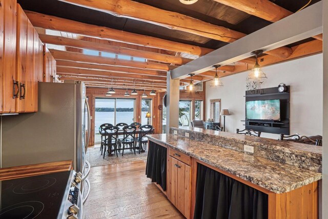 W9160 Ripley Rd, Cambridge, WI 53523 - kitchen featuring beamed ceiling, stainless steel appliances, hanging light fixtures, brown cabinets, and light wood finished floors
