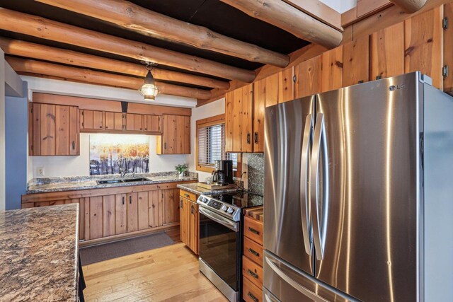 W9160 Ripley Rd, Cambridge, WI 53523 - kitchen featuring a sink, beamed ceiling, brown cabinetry, stainless steel appliances, and light wood-style flooring