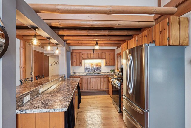 W9160 Ripley Rd, Cambridge, WI 53523 - kitchen with a sink, appliances with stainless steel finishes, brown cabinetry, pendant lighting, and light wood-style flooring