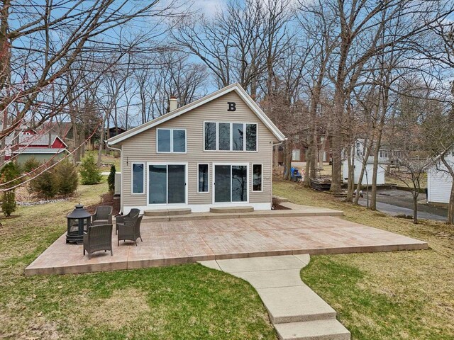 W9160 Ripley Rd, Cambridge, WI 53523 - back of house featuring entry steps, a patio, a lawn, and a chimney