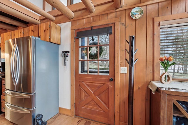 W9160 Ripley Rd, Cambridge, WI 53523 - kitchen with wooden walls, brown cabinetry, freestanding refrigerator, and light wood-style floors