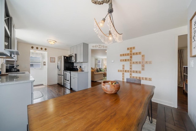 1501 Walls St, Green Bay, WI 54304 - dining space with a chandelier, baseboards, and dark wood-type flooring