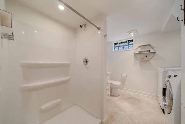 1501 Walls St, Green Bay, WI 54304 - bathroom featuring washer and clothes dryer, a shower, toilet, tile patterned floors, and baseboards