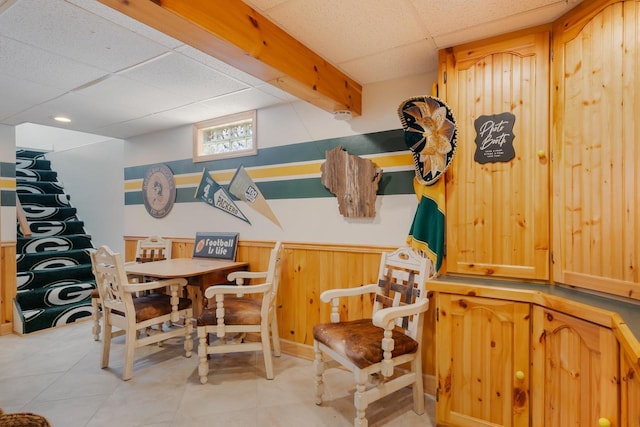 1501 Walls St, Green Bay, WI 54304 - dining room featuring a drop ceiling, a wainscoted wall, light tile patterned floors, and wooden walls