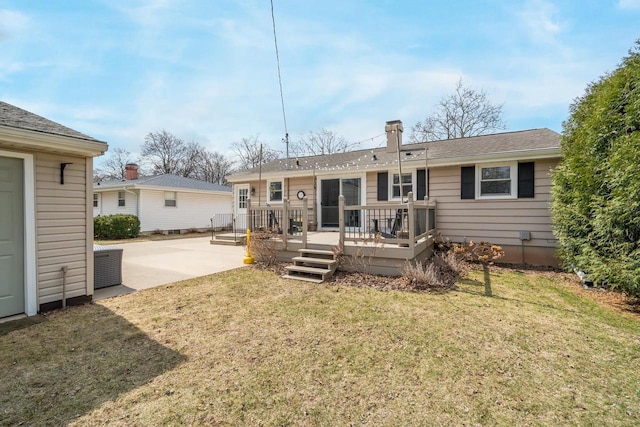 1501 Walls St, Green Bay, WI 54304 - back of property featuring a patio area, a lawn, a wooden deck, and a shingled roof