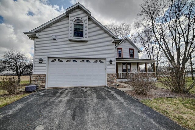 446 County Road Bb, Marshall, WI 53559 - traditional-style house with a garage, a porch, driveway, and stone siding