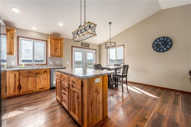 306 Dunn St, Colfax, WI 54730 - kitchen featuring a center island, dark wood-style floors, stainless steel dishwasher, decorative backsplash, and lofted ceiling