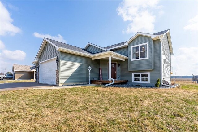 306 Dunn St, Colfax, WI 54730 - split level home featuring a front yard, driveway, and a garage