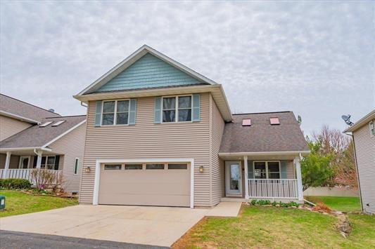 1359 Dianne Ave, Belleville, WI 53508 - view of front of property with a porch, driveway, a garage, and a front lawn